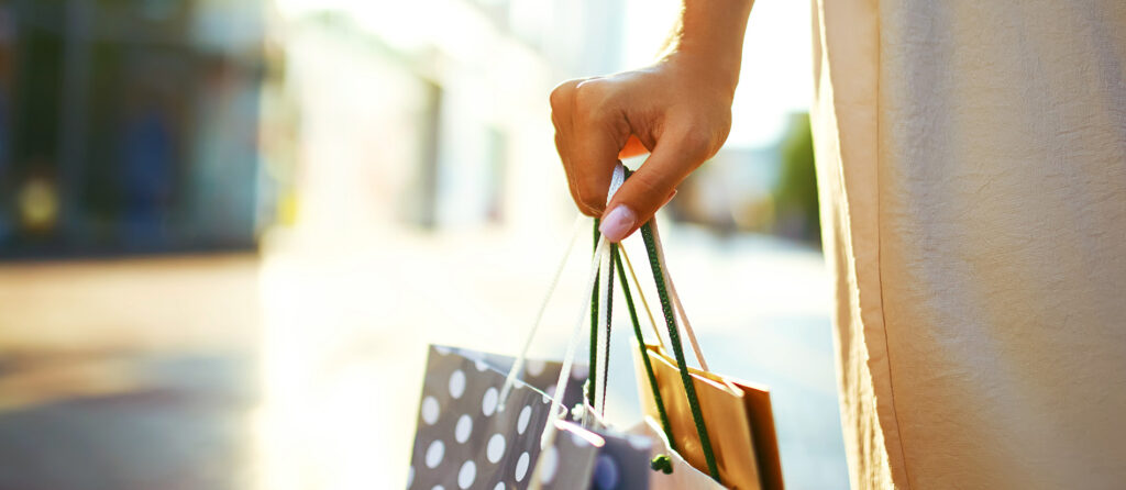 Shopping bags in the hands. Hand of young woman with shopping ba